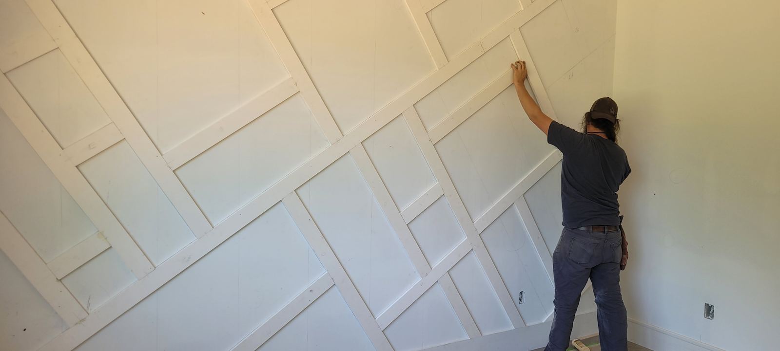 Carpenter fitting a geometric wall paneling detail